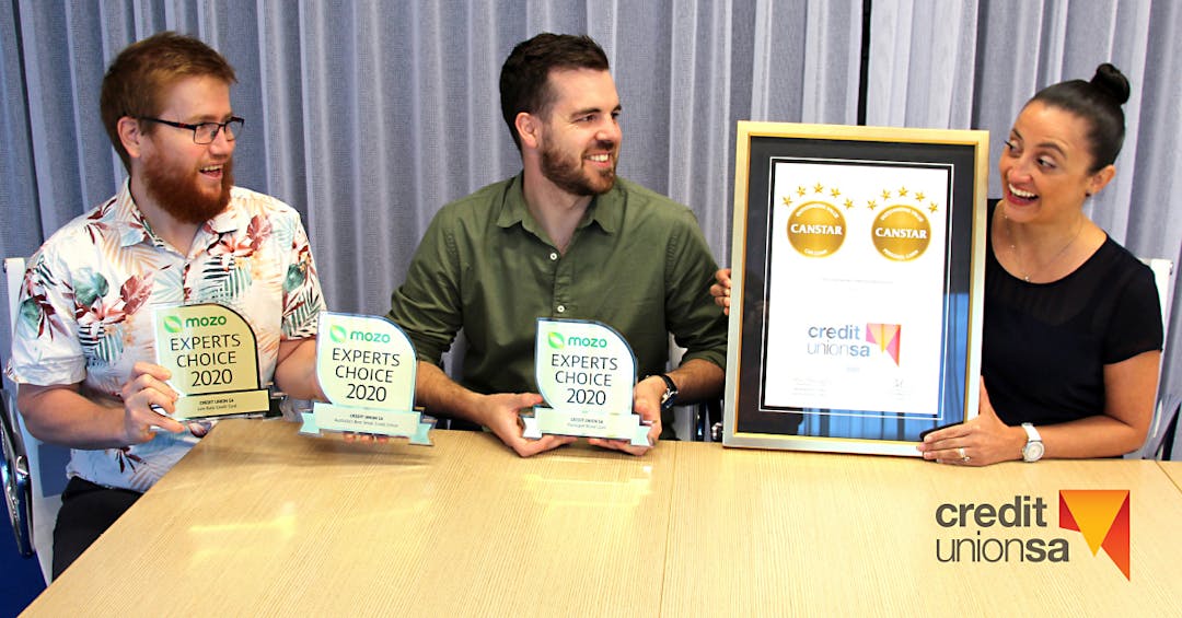 Three people holding up awards that Credit Union SA won
